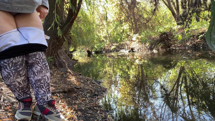 MILF dressed in leggings pissing in the river
