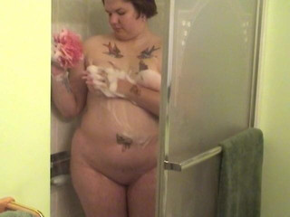 Tattooed fat chick strips to wash her tits and cunt in the shower