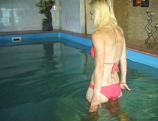 Hot blonde girl is having fun near the pool