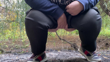 MILF dressed in pants pissing outdoors
